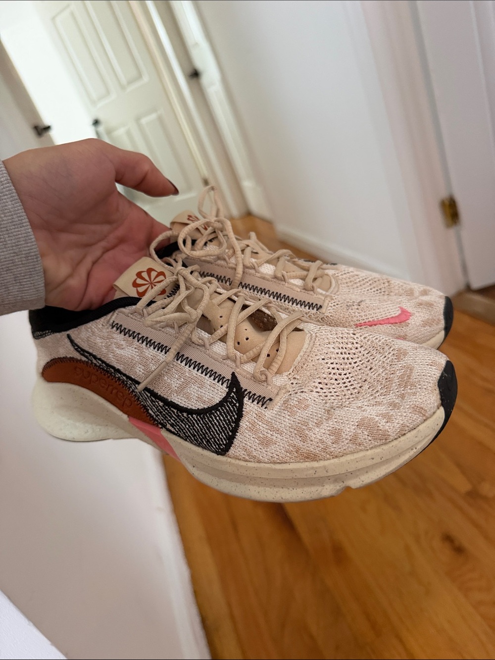 Nike Women’s Beige Flyknit Sneakers with Black Swoosh and Pink Accent